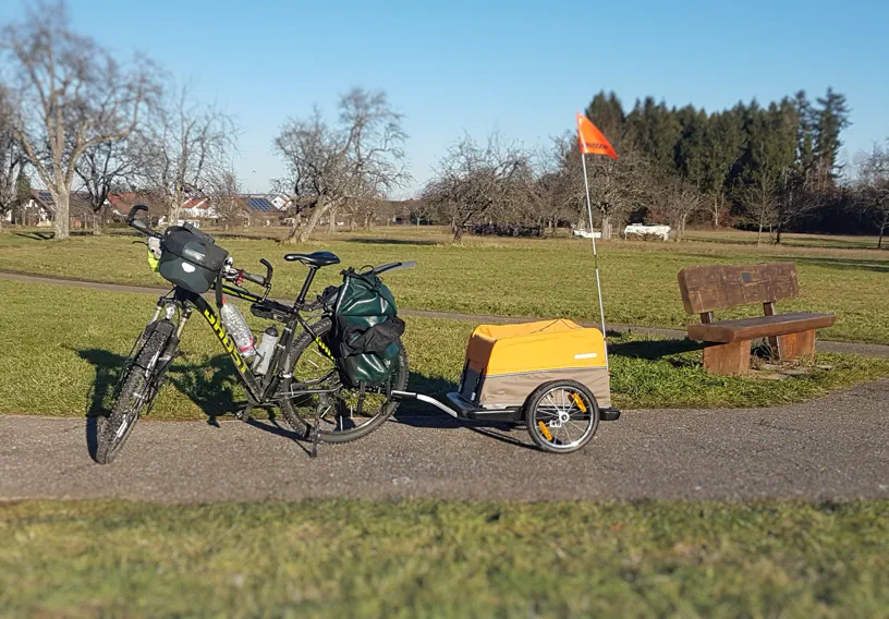Fahrradanhänger mit Fahrrad auf einem Feldweg Fahrradanhänger mit Fahrrad auf einem Feldweg